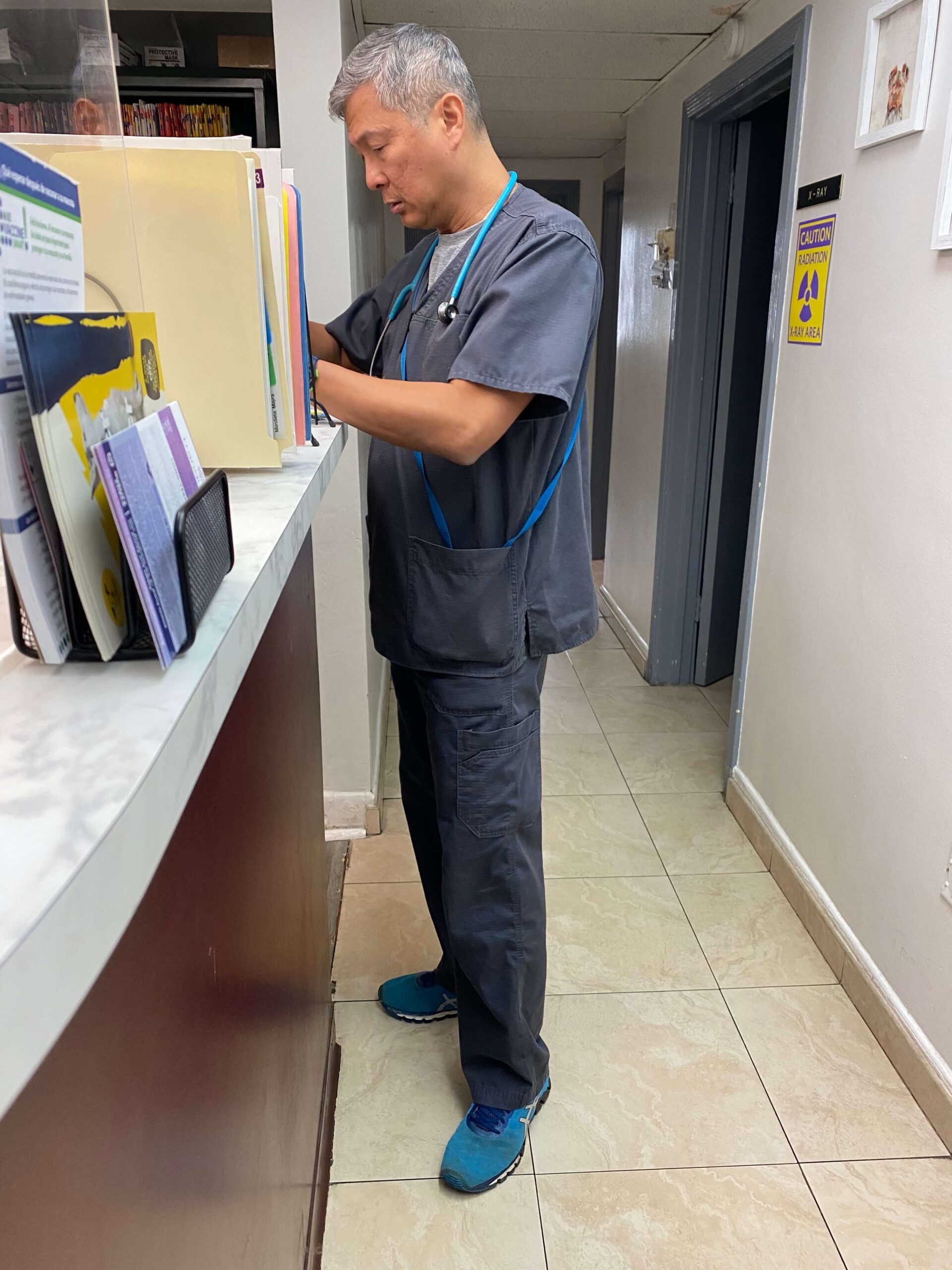 doctor in a scrubs standing at a reception desk